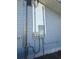 Exterior shot of the house displaying an electric meter attached to the gray siding at 8306 N Orleans Ave, Tampa, FL 33604