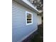 Side exterior view of the house with gray siding and a view of the backyard at 8306 N Orleans Ave, Tampa, FL 33604