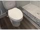 Bathroom featuring standard toilet with gray flooring at 8306 N Orleans Ave, Tampa, FL 33604