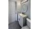 Bathroom with stylish vanity featuring a granite countertop, white cabinets, and a modern oval mirror at 9210 Crabtree Ln, Port Richey, FL 34668