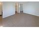 Spacious bedroom featuring neutral walls, tile flooring, and doorways to the bathroom and closet at 9210 Crabtree Ln, Port Richey, FL 34668