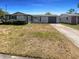 Charming single-story home with a well-maintained lawn and attached garage on a sunny day at 9210 Crabtree Ln, Port Richey, FL 34668