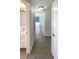 Hallway that leads to the bathroom featuring tile flooring and bright colors at 9210 Crabtree Ln, Port Richey, FL 34668