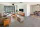 Open-concept living room with tile flooring, ceiling fan, and sliding glass doors leading to pool at 9210 Crabtree Ln, Port Richey, FL 34668