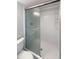 The bathroom features a shower with sliding glass doors and built-in shelving for convenience at 9210 Crabtree Ln, Port Richey, FL 34668