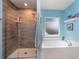 Bathroom featuring a tiled shower with glass door and soaking tub under a bright window at 2248 Bonn Ct, Punta Gorda, FL 33983