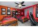 Bedroom with Buccaneers-themed decor, two beds, ceiling fan, and gray wood-look flooring at 2248 Bonn Ct, Punta Gorda, FL 33983