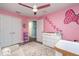 Bright Bedroom with a ceiling fan, a plush chair, polka dot wall decor, and gray wood-look flooring at 2248 Bonn Ct, Punta Gorda, FL 33983