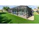 Screened-in pool area with artificial turf, a hot tub, and an outdoor seating area at 2248 Bonn Ct, Punta Gorda, FL 33983