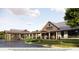 Exterior view of community clubhouse featuring a covered entryway and manicured landscaping at 2366 Wise River Lane, Zephyrhills, FL 33539