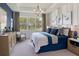 Bedroom featuring a large window with wooded views, stylish furnishings, and ample natural light at 2366 Wise River Lane, Zephyrhills, FL 33539
