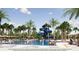 Community pool with waterslides, lounge chairs, and palm trees, perfect for outdoor recreation at 2366 Wise River Lane, Zephyrhills, FL 33539