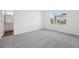 Well-lit bedroom showcasing neutral carpet, window with neighborhood view, and an ensuite bathroom at 6155 Pina Colada St, Zephyrhills, FL 33542