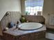 A tile-enclosed bathtub features a tiled backsplash and glass block window, creating a stylish bathing space at 4666 Clarke St, North Port, FL 34286