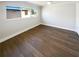 An empty room with luxury vinyl flooring and a window creates a modern and minimalist aesthetic at 10454 138Th St, Largo, FL 33774