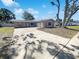 Charming home exterior with a two-car garage, spacious driveway, and mature trees at 10454 138Th St, Largo, FL 33774