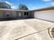Front exterior of home featuring a two-car garage and large driveway at 10454 138Th St, Largo, FL 33774