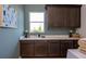 Functional laundry room with ample counter space, storage cabinets, and a utility sink at 2726 Wise River Lane, Zephyrhills, FL 33539