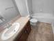 Bright bathroom featuring a white toilet, bathtub, and vanity with a sink and tiled floor at 1311 Trailwater St, Ruskin, FL 33570