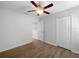 A bedroom featuring a ceiling fan, closet, wood floors, and access to the ensuite bathroom at 1311 Trailwater St, Ruskin, FL 33570