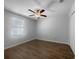 Bright bedroom featuring wood floors, a ceiling fan, and a large window at 1311 Trailwater St, Ruskin, FL 33570