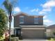 Charming two-story home with a two-car garage, landscaped yard, and a beautiful palm tree at 1311 Trailwater St, Ruskin, FL 33570