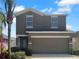 Charming two-story home with a two-car garage, landscaped yard, and a beautiful palm tree at 1311 Trailwater St, Ruskin, FL 33570