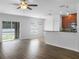 Bright living room featuring wood floors, ceiling fan, and sliding glass door to a screened porch at 1311 Trailwater St, Ruskin, FL 33570