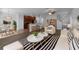 Open-concept living room flows seamlessly into the kitchen with sleek white furniture and striped area rug at 1311 Trailwater St, Ruskin, FL 33570