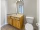 Bathroom featuring single sink vanity with wood cabinets, and a toilet at 30406 Arrochar St, Wesley Chapel, FL 33545