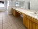 Bathroom featuring double sinks, tile floor, and a glass shower enclosure at 30406 Arrochar St, Wesley Chapel, FL 33545