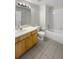 Bathroom featuring single sink vanity with wood cabinets, a mirror and tiled shower and tub at 30406 Arrochar St, Wesley Chapel, FL 33545