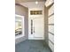 Inviting front entrance with a white door, sidelight window, and transom, offering plenty of natural light at 30406 Arrochar St, Wesley Chapel, FL 33545