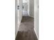 Hallway with neutral paint and carpet that runs the length of the home at 30406 Arrochar St, Wesley Chapel, FL 33545