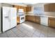 Well-equipped kitchen with wood cabinets, white appliances, tile flooring, and ample counter space at 30406 Arrochar St, Wesley Chapel, FL 33545