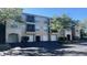 Beige condo building featuring private garages, screened in lanais, and lush landscaping at 5125 Palm Springs Blvd # 13107, Tampa, FL 33647