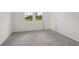 Bright bedroom with carpeted floors and two windows providing natural light at 14106 Crutchfield Ct, Parrish, FL 34219