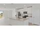 Eat-in kitchen island featuring a stainless steel sink, granite countertop, and white cabinets at 149 Whiteland Bnd, Nokomis, FL 34275