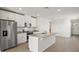 Spacious kitchen with white cabinets, stainless steel appliances, and an island with stone countertops at 149 Whiteland Bnd, Nokomis, FL 34275