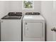 Laundry room includes a top-load washing machine, a front-load dryer, and a window for natural light at 149 Whiteland Bnd, Nokomis, FL 34275