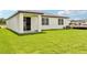 Expansive backyard featuring lush green grass and a covered patio, perfect for outdoor relaxation at 1752 Brekey Way, Zephyrhills, FL 33541