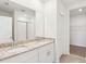 Modern bathroom featuring double sinks, granite countertops, white cabinetry, and tiled shower at 1752 Brekey Way, Zephyrhills, FL 33541
