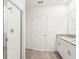 Modern bathroom with glass-enclosed shower, granite countertop vanity, and white tile flooring at 1752 Brekey Way, Zephyrhills, FL 33541