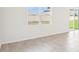 Spacious living area with neutral walls, tile flooring, and a window providing natural light at 1752 Brekey Way, Zephyrhills, FL 33541