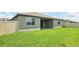 Backyard with lush green grass, fence, and a covered patio area at 1787 Draughton Dr, Zephyrhills, FL 33541