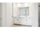 Bright bathroom with double vanity with granite countertops, white cabinets, and a large mirror at 1787 Draughton Dr, Zephyrhills, FL 33541