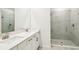 Modern bathroom featuring a double vanity with a separate glass enclosed shower, and grey tiling throughout at 1787 Draughton Dr, Zephyrhills, FL 33541