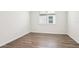 A bedroom offers wood-look flooring, white walls, baseboard trim and a window with blinds at 1787 Draughton Dr, Zephyrhills, FL 33541