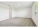 Neutral bedroom with carpeted floors, a window bringing in natural light, and a door leading to another room at 1787 Draughton Dr, Zephyrhills, FL 33541