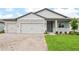 Charming single-story home with a two-car garage, and inviting front yard with beautiful brick paver driveway at 1787 Draughton Dr, Zephyrhills, FL 33541